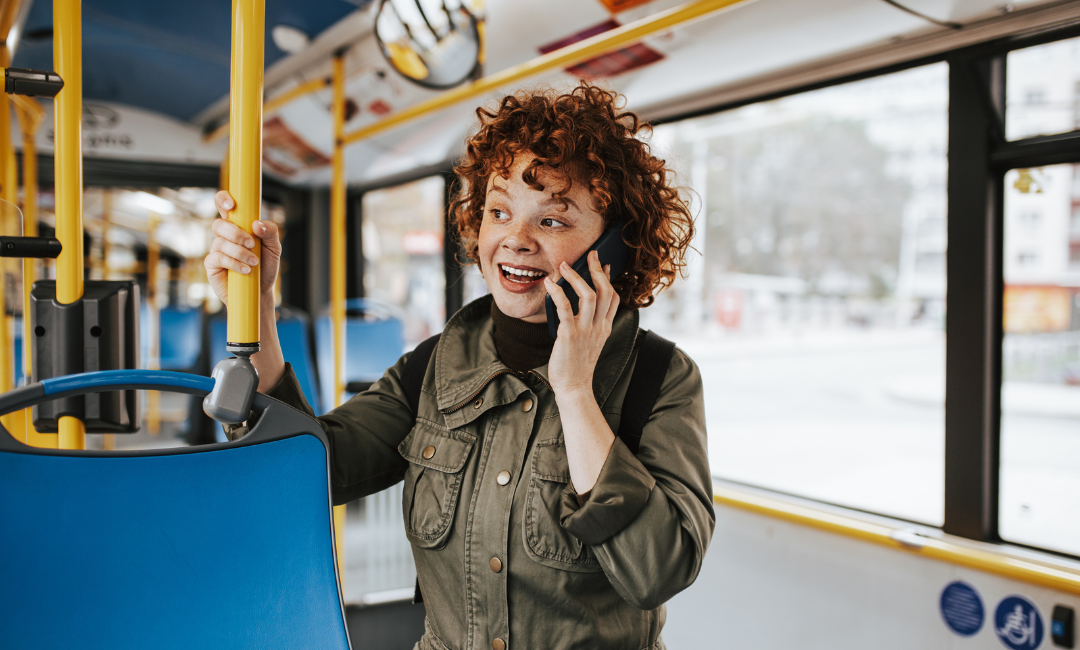Une femme rousse qui parle au téléphone dans un autobus